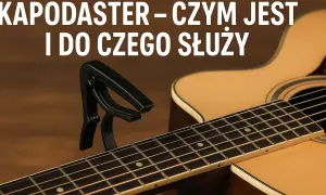 Czarny kapodaster na gryfie gitary akustycznej. Dowiedz się, kapodaster co to i jak ułatwia grę.