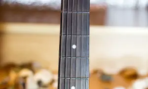 Gryf gitary z progami i progami, gotowy do wykonania najpiękniejszych utworów gitarowych.