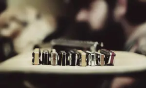 Rząd harmonijek ustnych, w tym taby na harmonijkę c, leży na drewnianym blacie.