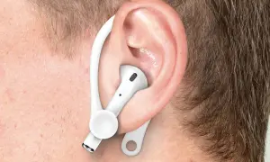 Ucho z białą słuchawką AirPods i zaczepem, pokazujące, jak poprawnie nosić Airpods dla lepszego dopasowania.