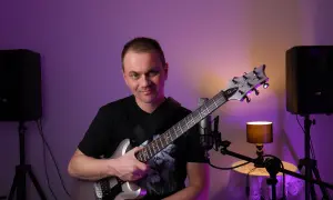 Mężczyzna z gitarą elektryczną, gotowy do nauki gry na gitarze online za darmo.