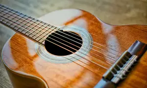 Piękna gitara klasyczna, idealna do nauki gry. Jej ciepłe drewno i błyszczące struny zapraszają do muzykowania.