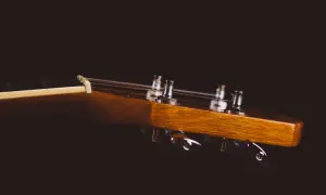 Drewniana główka gitary klasycznej z widocznymi kluczami strojeniowymi. Idealne miejsce, by zacząć naukę, jak nastroić gitarę klasyczną.