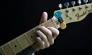 Dłoń grająca akord C na gitarze Fender Telecaster. Kostki z uchwytem na gryfie.