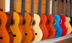 Rząd kolorowych gitar akustycznych, od pomarańczowej po czerwoną i niebieską, prezentuje różne rodzaje gitar akustycznych.