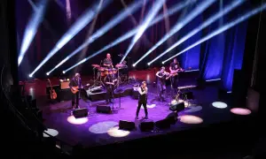 Zespół muzyczny na scenie, grający w rytm rubato, oświetlony niebieskimi i białymi światłami.
