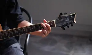 Dłoń grająca akord na gitarze klasycznej. Gwiazdki na gryfie dodają uroku, a całość przywodzi na myśl najładniejsze utwory na gitarę klasyczną.