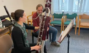 Kobieta i mężczyzna ćwiczą grę na fagotach, instrumentach muzycznych.