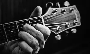 Dłoń z pierścionkiem na serdecznym palcu chwyta akord na gryfie gitary. Powstają piękne utwory na gitarę.