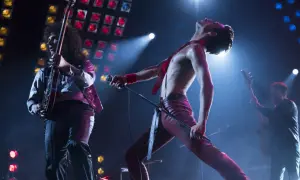 Freddie Mercury śpiewa "Bohemian Rhapsody", a jego zespół gra na żywo. Nuty tej ikonicznej piosenki rozbrzmiewają na koncercie.