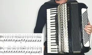 Osoba gra na akordeonie HOHNER, a przed nią leży nuta z zapisem melodii. To z pewnością materiał na przeboje na akordeon!
