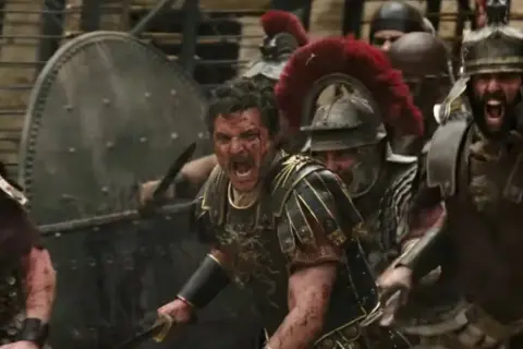 Żołnierze w zbrojach i hełmach, jeden z nich krzyczy. Muzyka do "Gladiatora" Hansa Zimmera budzi emocje.