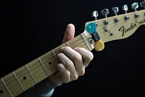 Dłoń grająca akord C na gitarze Fender Telecaster. Kostki z uchwytem na gryfie.