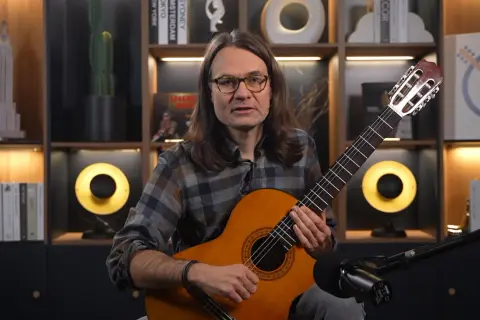 Mężczyzna gra na gitarze klasycznej, idealnej do nauki. Proste nuty na gitarze dla początkujących czekają na odkrycie.