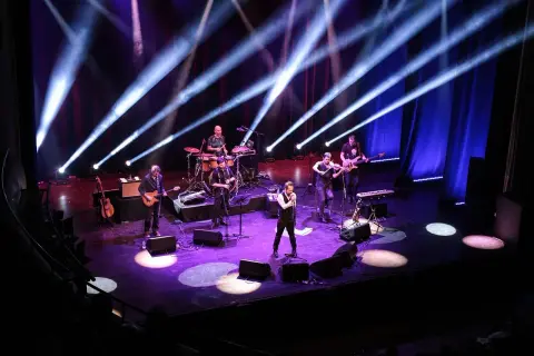 Zespół muzyczny na scenie, grający w rytm rubato, oświetlony niebieskimi i białymi światłami.