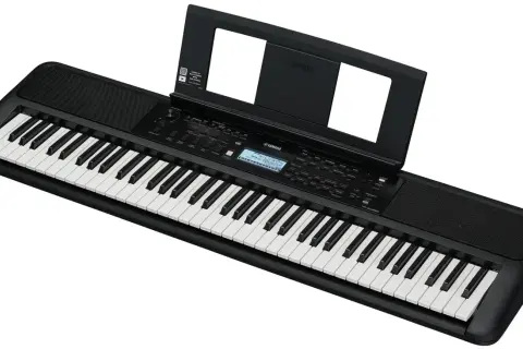 Czarny keyboard Yamaha z nutami na stojaku. Idealny do nauki gry, świetny w rankingu keyboardów dla dzieci.