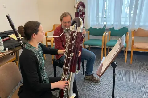 Kobieta i mężczyzna ćwiczą grę na fagotach, instrumentach muzycznych.