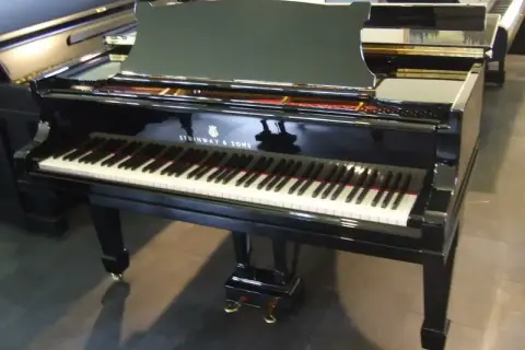 Błyszczący fortepian Steinway & Sons, jeden z najbardziej cenionych **marek fortepianów**, gotowy do wykonania pięknej melodii.