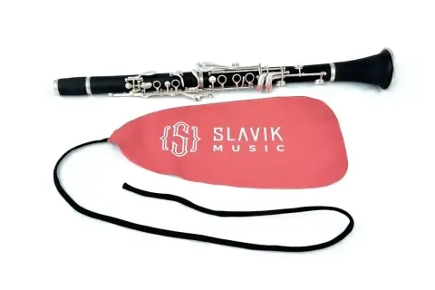 Czarny klarnet, jaki to instrument, leży obok różowego pokrowca z logo Slavik Music.