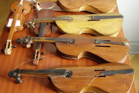 Rząd starych instrumentów smyczkowych. Czy to pudło skrzypiec jak się nazywa?