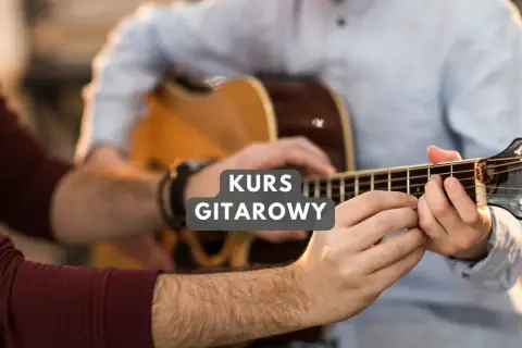 Nauczyciel pokazuje uczniowi, jak prawidłowo chwytać akordy na gitarze. "Mam te moc chwyty" - mówi uczeń, czując postęp.
