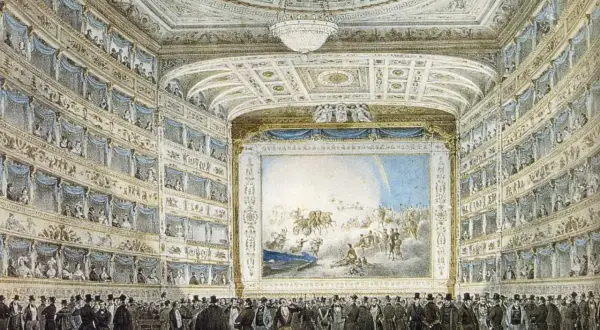 Widownia teatru z lożami pełnymi widzów, scena z malowidłem i tłum elegancko ubranych panów na parterze. Idealne miejsce na opery Verdiego.