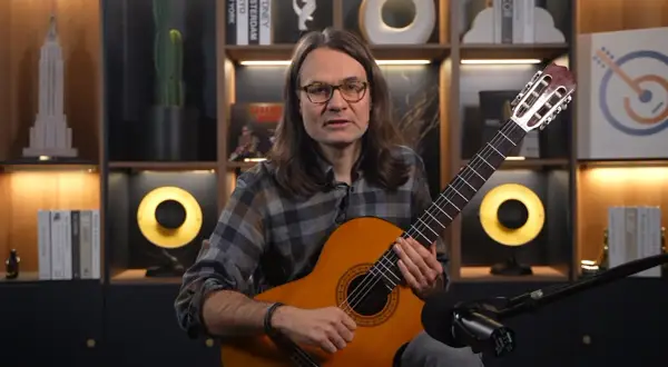 Mężczyzna gra na gitarze klasycznej, idealnej do nauki. Proste nuty na gitarze dla początkujących czekają na odkrycie.