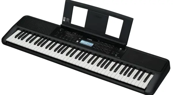 Czarny keyboard Yamaha z nutami na stojaku. Idealny do nauki gry, świetny w rankingu keyboardów dla dzieci.