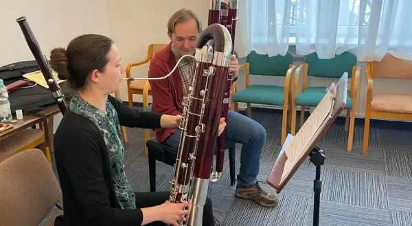 Kobieta i mężczyzna ćwiczą grę na fagotach, instrumentach muzycznych.
