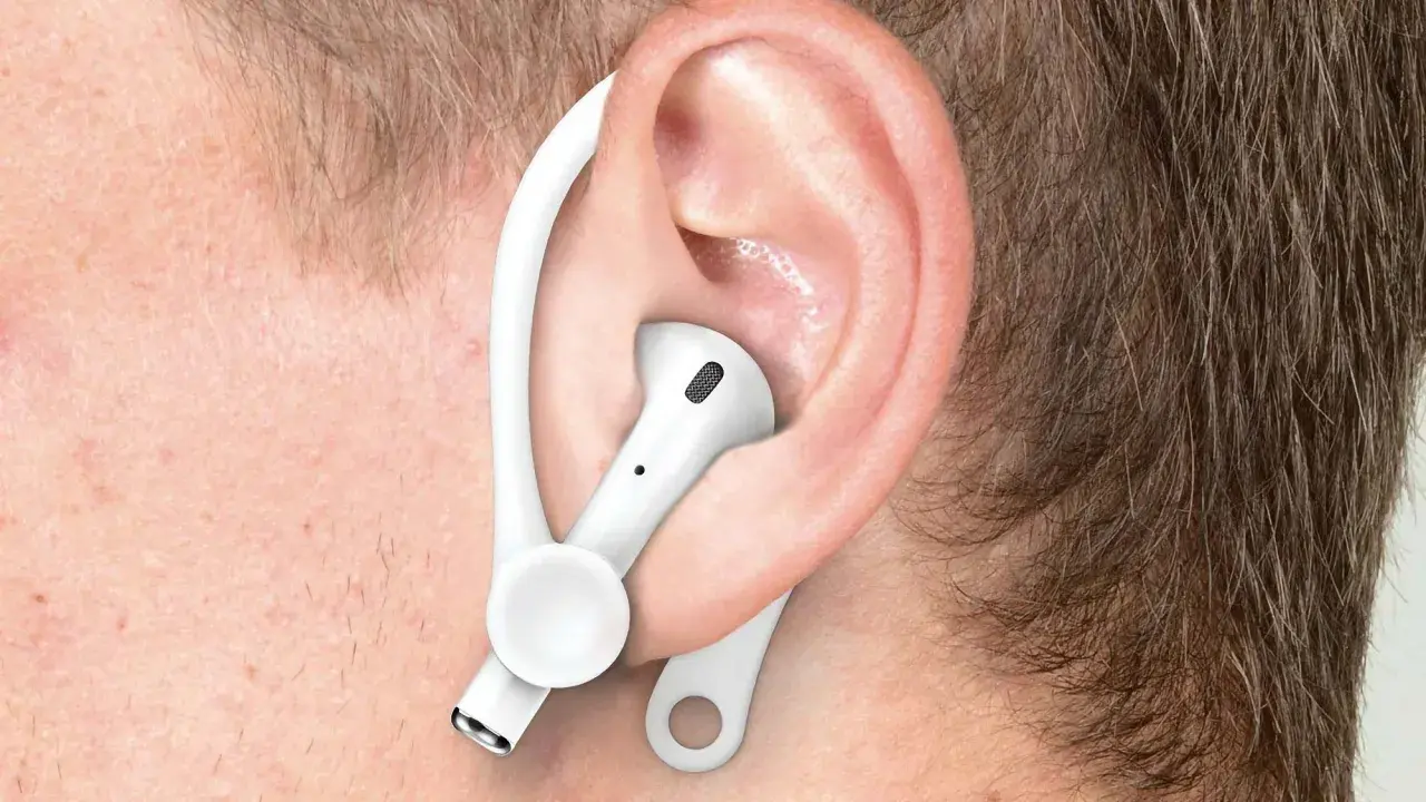 Ucho z białą słuchawką AirPods i zaczepem, pokazujące, jak poprawnie nosić Airpods dla lepszego dopasowania.
