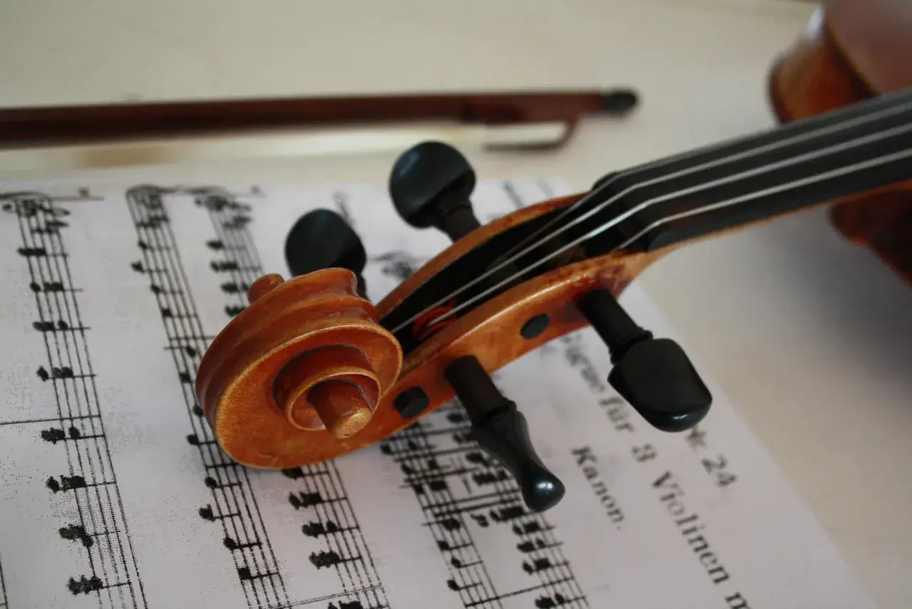 Nuty na skrzypce dla początkujących leżą obok instrumentu.