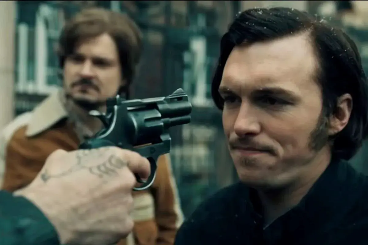 Scena z filmu, gdzie gangster celuje z rewolweru. Może to być moment z "Jak pokochałam gangstera", pełen napięcia i niepewności.