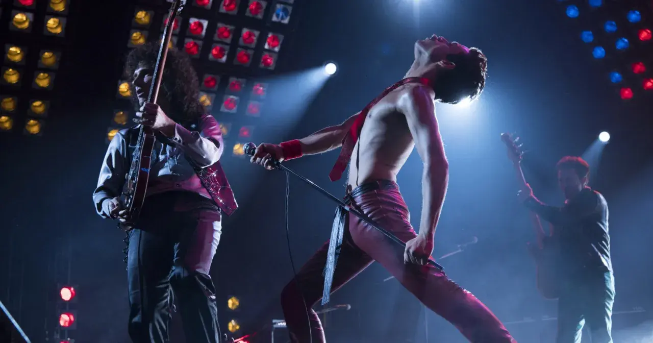 Freddie Mercury śpiewa "Bohemian Rhapsody", a jego zespół gra na żywo. Nuty tej ikonicznej piosenki rozbrzmiewają na koncercie.
