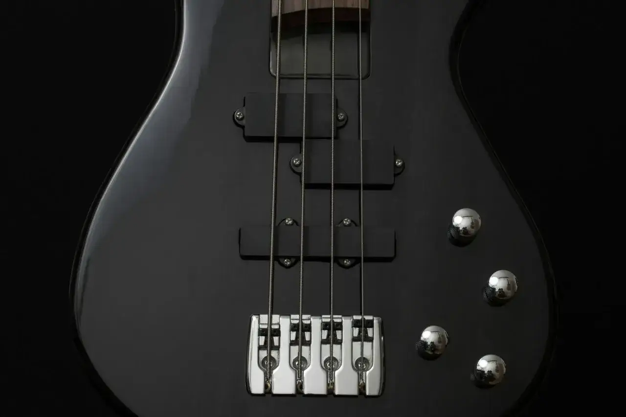 Czarna gitara basowa z czterema strunami, gotowa do wydobycia głębokich dźwięków.