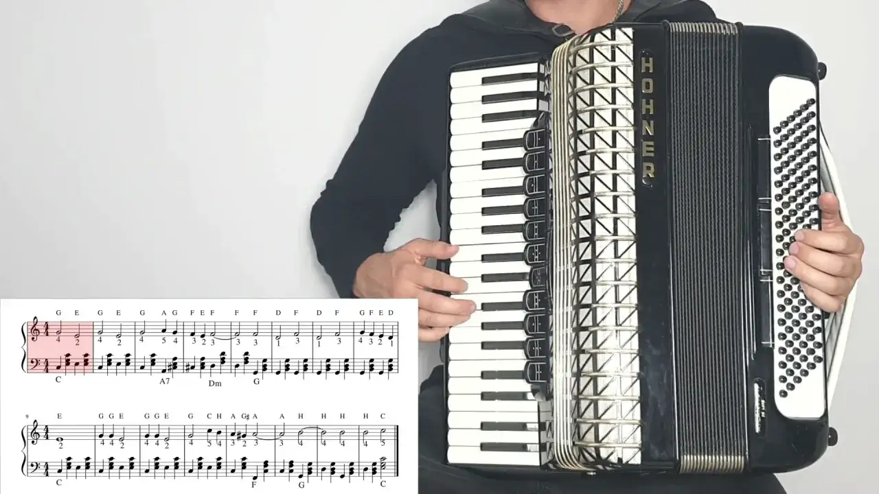 Akordeonista grający najpiękniejsze melodie świata. Na ekranie nuty i klawisze akordeonu.