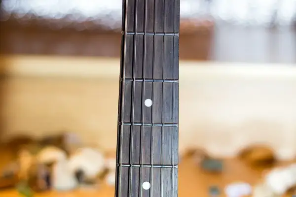 Gryf gitary z progami i progami, gotowy do wykonania najpiękniejszych utworów gitarowych.