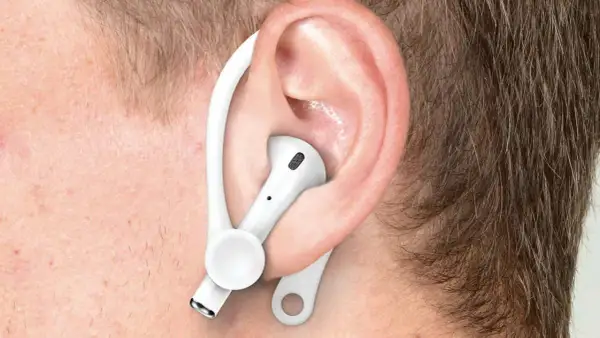 Ucho z białą słuchawką AirPods i zaczepem, pokazujące, jak poprawnie nosić Airpods dla lepszego dopasowania.