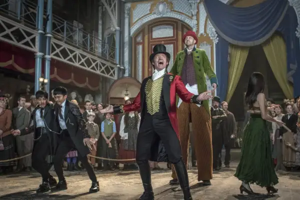 Król rozrywki, P.T. Barnum, w cyrkowym stroju wita publiczność. W tle widzimy jego artystów i widzów.