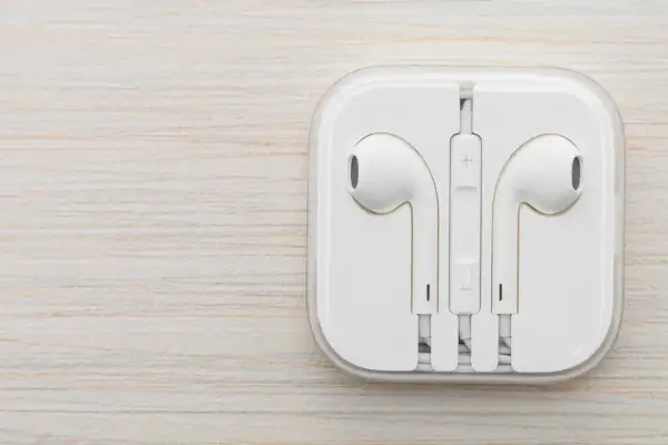Białe słuchawki w etui. Czy do iPhone pasują inne słuchawki? Tak, ale te są oryginalne.