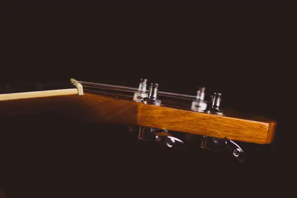 Drewniana główka gitary klasycznej z widocznymi kluczami strojeniowymi. Idealne miejsce, by zacząć naukę, jak nastroić gitarę klasyczną.