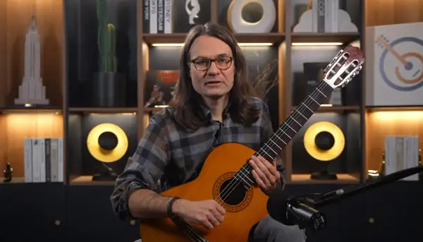 Mężczyzna gra na gitarze klasycznej, idealnej do nauki. Proste nuty na gitarze dla początkujących czekają na odkrycie.