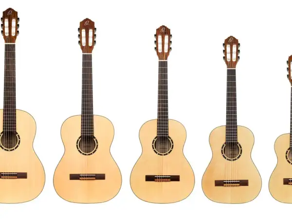 Rząd gitar klasycznych i akustycznych. Zobacz, czym się różni gitara klasyczna od akustycznej, porównując ich rozmiary i detale.