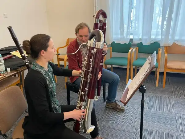 Kobieta i mężczyzna ćwiczą grę na fagotach, instrumentach muzycznych.