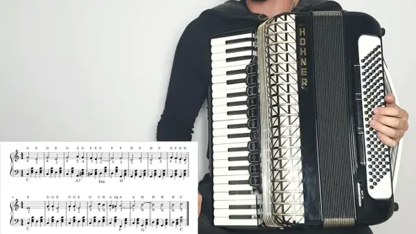 Osoba gra na akordeonie HOHNER, a przed nią leży nuta z zapisem melodii. To z pewnością materiał na przeboje na akordeon!